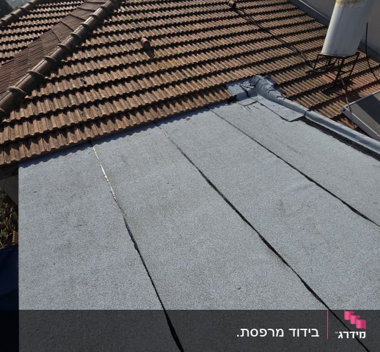 גג עם יריעות איטום אפורות וחיבורים גלויים